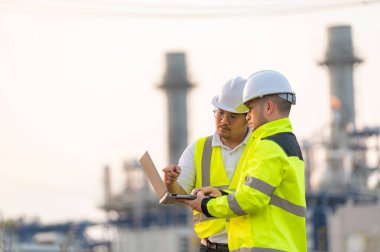 Petrol ve gaz rafinerisi fabrikasında çalışan Asyalı bir grup petrokimya mühendisi elektrik santrali enerji imalatında çalışan insan işçi mühendisi.