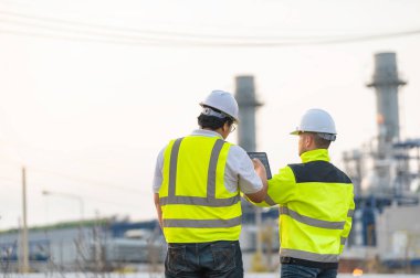 Petrol ve gaz rafinerisi fabrikasında çalışan Asyalı bir grup petrokimya mühendisi elektrik santrali enerji imalatında çalışan insan işçi mühendisi.