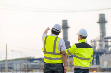 Petrol ve gaz rafinerisi fabrikasında çalışan Asyalı bir grup petrokimya mühendisi elektrik santrali enerji imalatında çalışan insan işçi mühendisi.