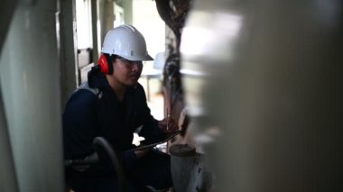 Makine mühendisi fabrikadaki büyük makineleri inceliyor. Demiryolu motor bakım teknisyeni, motor tamircisi.