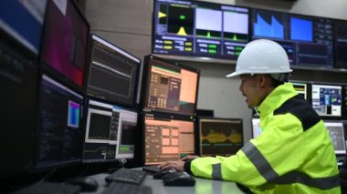 Kontrol odasında çalışan mühendis, yönetici kontrol sistemi, birçok monitörden teknisyen izleme programı.