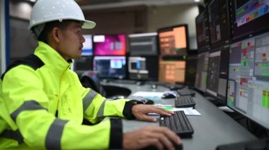 Kontrol odasında çalışan mühendis, yönetici kontrol sistemi, birçok monitörden teknisyen izleme programı.