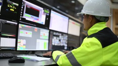 Kontrol odasında çalışan mühendis, yönetici kontrol sistemi, birçok monitörden teknisyen izleme programı.