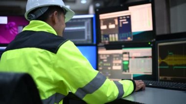 Kontrol odasında çalışan mühendis, yönetici kontrol sistemi, birçok monitörden teknisyen izleme programı.