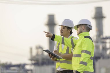 Petrol ve gaz rafinerisi fabrikasında çalışan Asyalı bir grup petrokimya mühendisi elektrik santrali enerji imalatında çalışan insan işçi mühendisi.