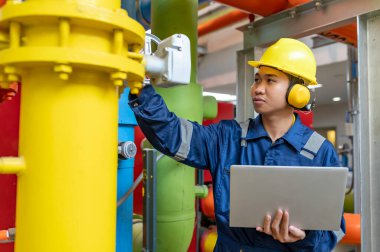 Bir ısıtma tesisinde bakım teknisyeni, Petrokimya işçileri fabrikadaki gaz ve petrol boru hatlarının işleyişini denetliyor, mühendisler işitme koruyucularını birçok boruyla aynı odaya koyuyorlar.