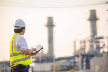 Petrol ve gaz rafinerisi fabrikasında çalışan Asyalı petrokimya mühendisi elektrik santrali enerji imalatında çalışan insan işçi mühendisi.