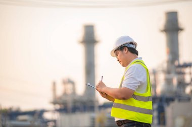 Petrol ve gaz rafinerisi fabrikasında çalışan Asyalı petrokimya mühendisi elektrik santrali enerji imalatında çalışan insan işçi mühendisi.