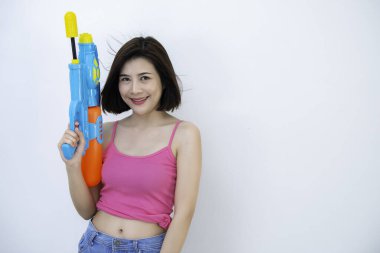 Beyaz arka planda elinde silah olan Asyalı seksi kadın Tayland 'da Songkran Festivali, Tayland Festivali' nin en iyi festivali, gülümseme ülkesi.