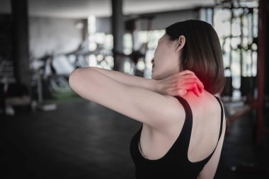 İnce Asyalı kadın spor salonunda spor yapıyor, egzersizden dolayı acı çekiyor.
