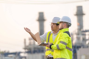 Petrol ve gaz rafinerisi fabrikasında çalışan Asyalı bir grup petrokimya mühendisi elektrik santrali enerji imalatında çalışan insan işçi mühendisi.