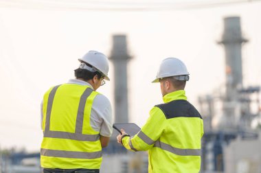 Petrol ve gaz rafinerisi fabrikasında çalışan Asyalı bir grup petrokimya mühendisi elektrik santrali enerji imalatında çalışan insan işçi mühendisi.