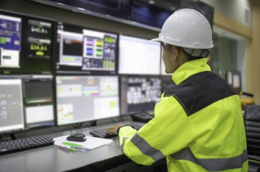 Kontrol odasında çalışan mühendis, yönetici kontrol sistemi, birçok monitörden teknisyen izleme programı.