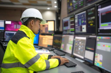 Kontrol odasında çalışan mühendis, yönetici kontrol sistemi, birçok monitörden teknisyen izleme programı.