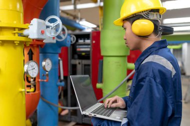 Bir ısıtma tesisinde bakım teknisyeni, Petrokimya işçileri fabrikadaki gaz ve petrol boru hatlarının işleyişini denetliyor, mühendisler işitme koruyucularını birçok boruyla aynı odaya koyuyorlar.