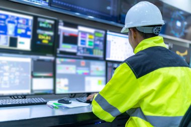 Kontrol odasında çalışan mühendis, yönetici kontrol sistemi, birçok monitörden teknisyen izleme programı.