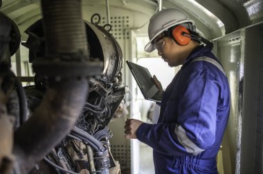 Makine mühendisi fabrikadaki büyük makineleri inceliyor, demiryolu motor bakım teknisyeni, motor tamircisi