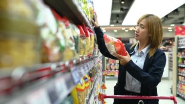 Güzel Asyalı kadın süpermarkette alışveriş yapıyor. Rahatlama zamanı, yemek ısmarla. Taylandlılar. Mutlu yaşam tarzı konsepti