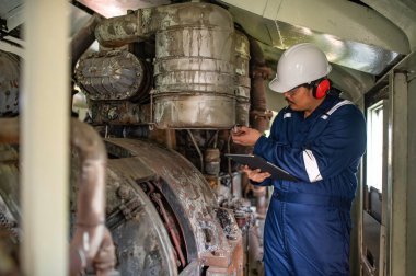 Makine mühendisi fabrikadaki büyük makineleri inceliyor, demiryolu motor bakım teknisyeni, motor tamircisi