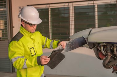 Teknisyen uçağın motorunu tamir ediyor, kadın uzay mühendisliği uçak motorlarını kontrol ediyor, Asyalı tamirci uçak motorlarını kontrol ediyor.