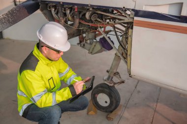 Teknisyen uçağın motorunu tamir ediyor, kadın uzay mühendisliği uçak motorlarını kontrol ediyor, Asyalı tamirci uçak motorlarını kontrol ediyor.