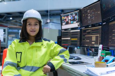 Büyük fabrikada yüksek performanslı bilgisayarlarda çalışan mühendis bilgisayar işçisi, büyük makinelerin işleyişini kontrol eden, robotu çalıştırmak için bir program yazan, ciddi programcı