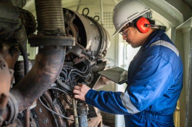 Makine mühendisi fabrikadaki büyük makineleri inceliyor, demiryolu motor bakım teknisyeni, motor tamircisi