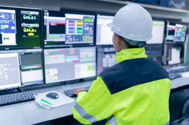 Kontrol odasında çalışan mühendis, yönetici kontrol sistemi, birçok monitörden teknisyen izleme programı.