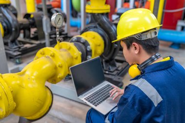 Bir ısıtma tesisinde bakım teknisyeni, Petrokimya işçileri fabrikadaki gaz ve petrol boru hatlarının işleyişini denetliyor, mühendisler işitme koruyucularını birçok boruyla aynı odaya koyuyorlar.