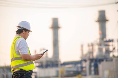 Petrol ve gaz rafinerisi fabrikasında çalışan Asyalı petrokimya mühendisi elektrik santrali enerji imalatında çalışan insan işçi mühendisi.