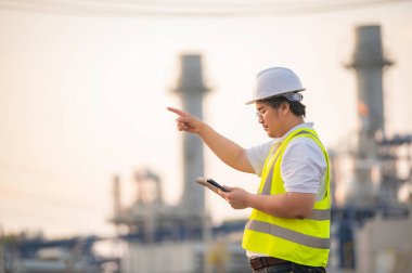 Petrol ve gaz rafinerisi fabrikasında çalışan Asyalı petrokimya mühendisi elektrik santrali enerji imalatında çalışan insan işçi mühendisi.