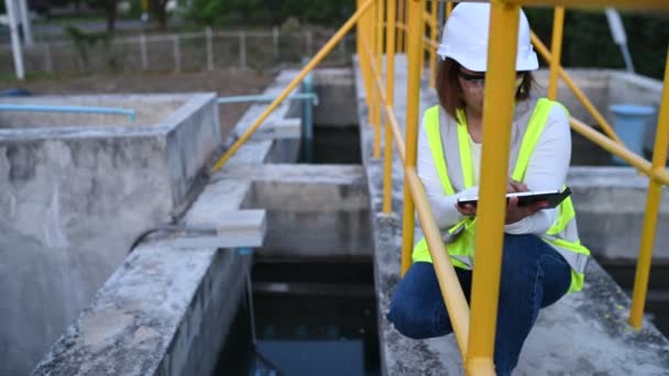 建筑工地上身穿信号弹背心和钢盔的亚洲女工程师 — 图库视频影像