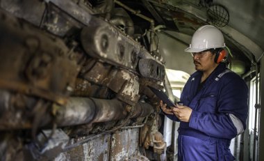 Makine mühendisi fabrikadaki büyük makineleri inceliyor, demiryolu motor bakım teknisyeni, motor tamircisi