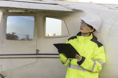 Teknisyen uçağın motorunu tamir ediyor, kadın uzay mühendisliği uçak motorlarını kontrol ediyor, Asyalı tamirci uçak motorlarını kontrol ediyor.