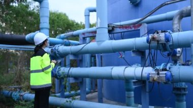 Çevre mühendisleri atık su arıtma tesislerinde çalışıyor. Su ikmali yapan kadın tesisatçı teknisyen.