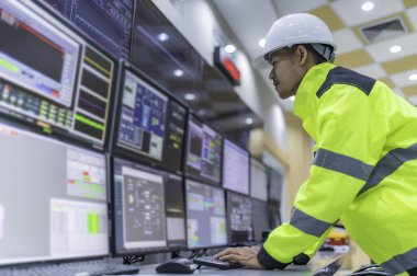 Kontrol odasında çalışan mühendis, yönetici kontrol sistemi, birçok monitörden teknisyen izleme programı.