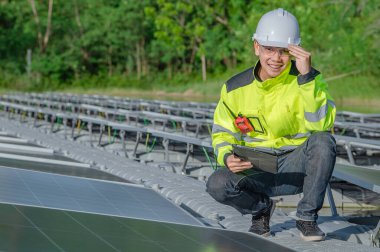 Yüzen güneş enerjisi santralinde çalışan Asyalı mühendis, yenilenebilir enerji, teknisyen ve yatırımcı güneş panelleri güneş enerjisi kurulumundaki panelleri kontrol ediyor