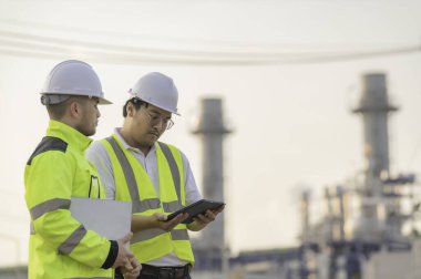Petrol ve gaz rafinerisi fabrikasında çalışan Asyalı bir grup petrokimya mühendisi elektrik santrali enerji imalatında çalışan insan işçi mühendisi.