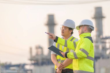 Petrol ve gaz rafinerisi fabrikasında çalışan Asyalı bir grup petrokimya mühendisi elektrik santrali enerji imalatında çalışan insan işçi mühendisi.