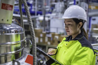 Tayland 'da, ameliyathanede çalışan Asyalı mühendis kask takıyor, özenle ve sabırla çalışıyor, hidrojen tankının valf düzenleyicisini kontrol ediyor..