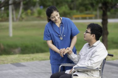 Hastanedeki bir hastayla ilgilenen hemşire, fizik tedavi gören bir hastaya yardım eden kadın doktor.