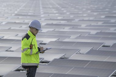 Yüzen güneş enerjisi santralinde çalışan Asyalı mühendis, yenilenebilir enerji, teknisyen ve yatırımcı güneş panelleri güneş enerjisi kurulumundaki panelleri kontrol ediyor