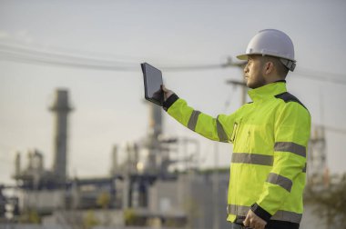 Petrol ve gaz rafinerisi fabrikasında çalışan Asyalı petrokimya mühendisi elektrik santrali enerji imalatında çalışan insan işçi mühendisi.