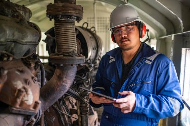 Makine mühendisi fabrikadaki büyük makineleri inceliyor, demiryolu motor bakım teknisyeni, motor tamircisi