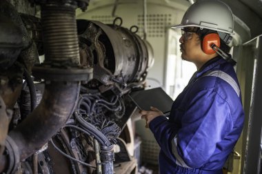 Makine mühendisi fabrikadaki büyük makineleri inceliyor, demiryolu motor bakım teknisyeni, motor tamircisi