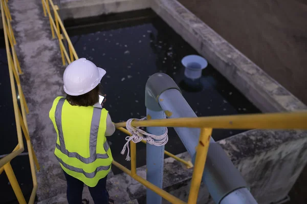 廃水処理施設で働く環境技術者 再利用のための水循環施設で働く水供給技術者 基準内にある水中塩素の量を確認する ストックフォト