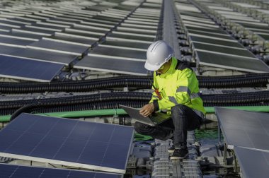 Yüzen güneş enerjisi santralinde çalışan Asyalı mühendis, yenilenebilir enerji, teknisyen ve yatırımcı güneş panelleri güneş enerjisi kurulumundaki panelleri kontrol ediyor