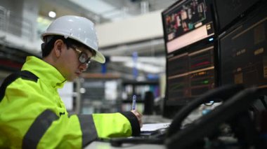 Kontrol odasında çalışan bir mühendis. Yönetici kontrol sistemi. Birçok monitörden teknisyen izleme programı