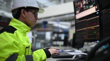 Kontrol odasında çalışan bir mühendis. Yönetici kontrol sistemi. Birçok monitörden teknisyen izleme programı
