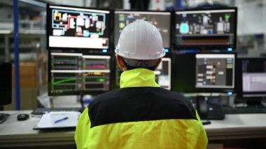 Kontrol odasında çalışan bir mühendis. Yönetici kontrol sistemi. Birçok monitörden teknisyen izleme programı